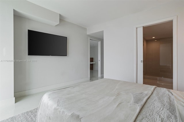 bedroom with ensuite bath and baseboards