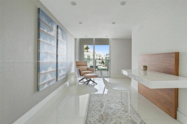 interior space featuring light tile patterned floors, baseboards, a wall of windows, and recessed lighting