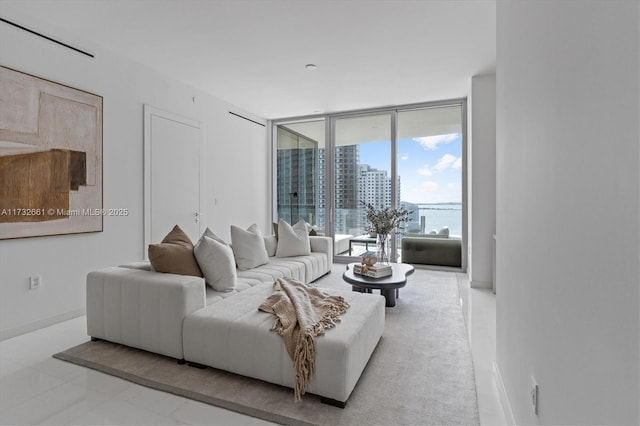 living area featuring baseboards, floor to ceiling windows, and a city view