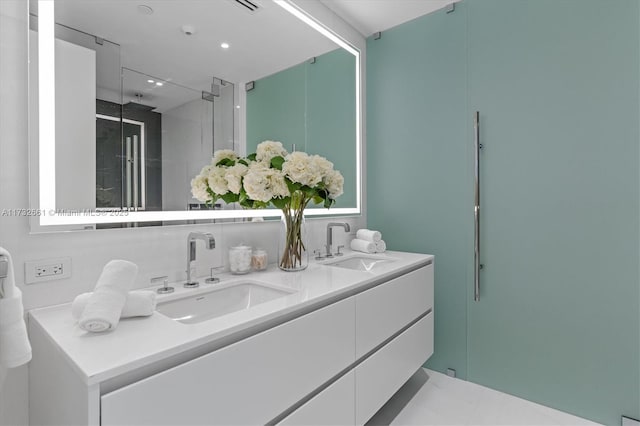 bathroom featuring a stall shower, a sink, and double vanity