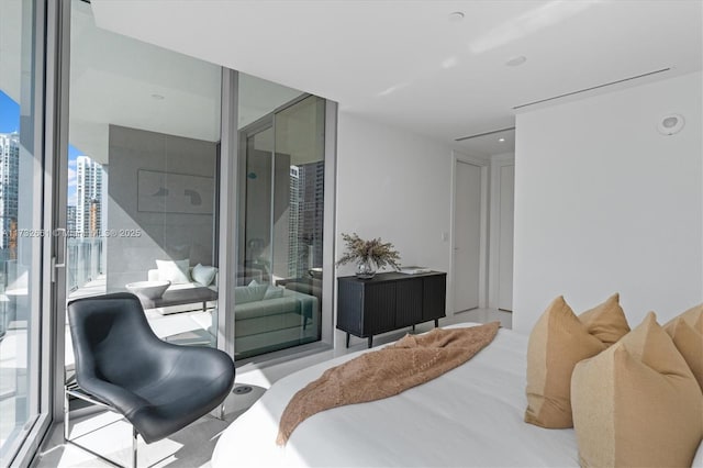 bedroom with access to exterior, expansive windows, and a view of city