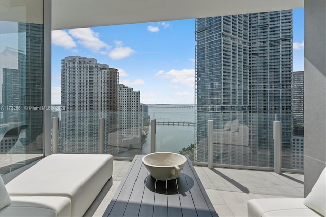 balcony featuring a water view and a city view