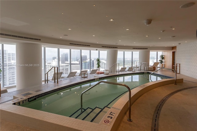 pool featuring a city view and a hot tub