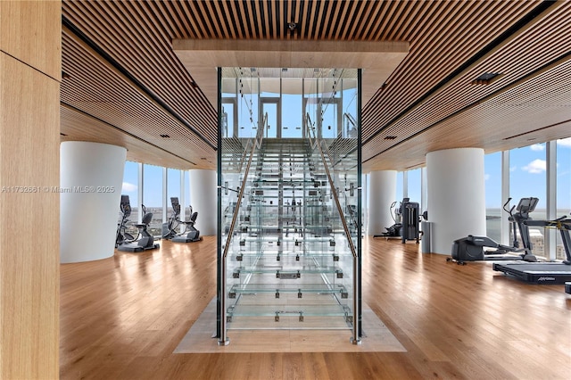 exercise room with light wood-style flooring and floor to ceiling windows