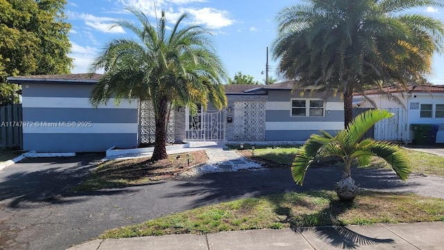 view of front of home with a gate, fence, and stucco siding