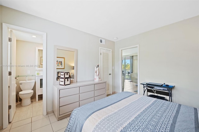 bedroom with visible vents, ensuite bathroom, and light tile patterned floors