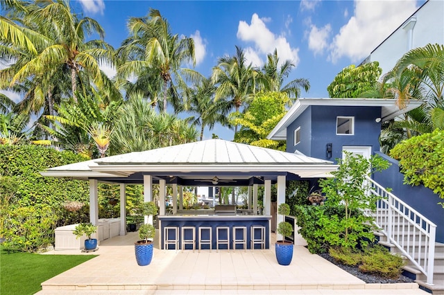 view of community with a patio area, stairs, outdoor dry bar, and a gazebo