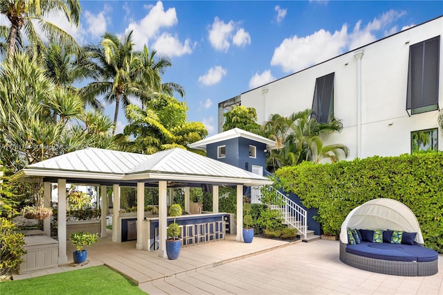 view of property's community featuring a wooden deck, outdoor dry bar, and a gazebo