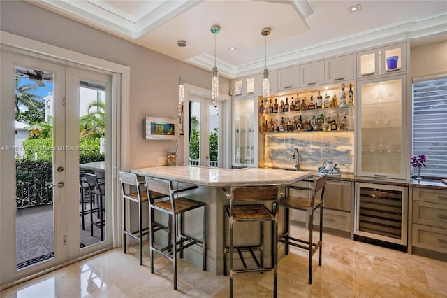 bar with wine cooler, a tray ceiling, french doors, pendant lighting, and indoor wet bar