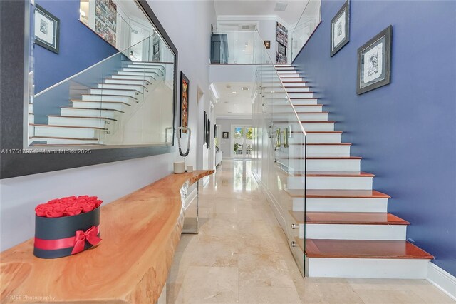 755 NE 77th St, Miami, FL 33138 - stairway featuring ornamental molding, a towering ceiling, and baseboards
