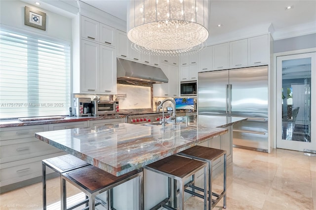 755 NE 77th St, Miami, FL 33138 - kitchen featuring a sink, built in appliances, under cabinet range hood, a toaster, and a notable chandelier