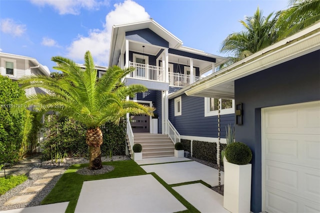 rear view of property with a balcony, an attached garage, and stucco siding