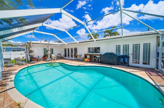 outdoor pool featuring a lanai, a patio, and area for grilling