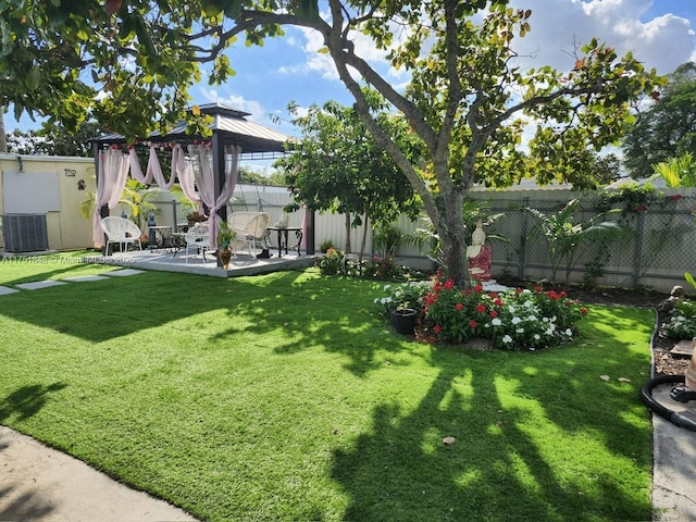 view of yard featuring a patio area, a fenced backyard, central AC, and a gazebo