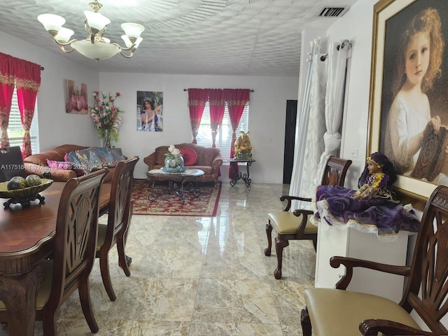 dining room with marble finish floor, a textured ceiling, visible vents, and a notable chandelier