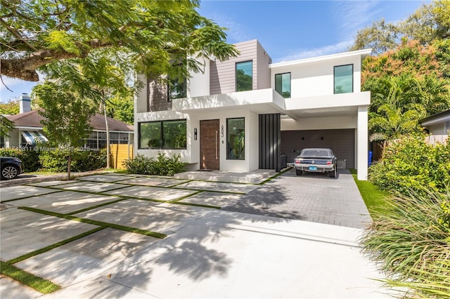 modern home with decorative driveway and stucco siding