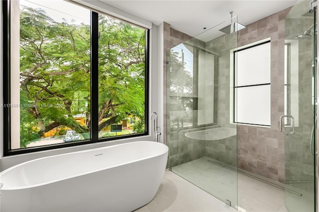 bathroom featuring a stall shower and a freestanding tub