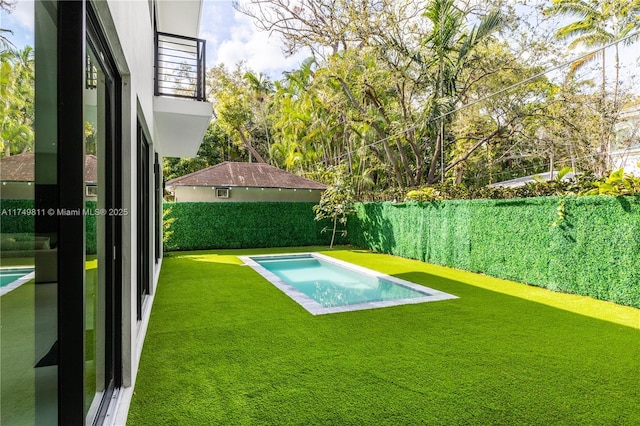 view of swimming pool with a fenced in pool, a fenced backyard, and a yard