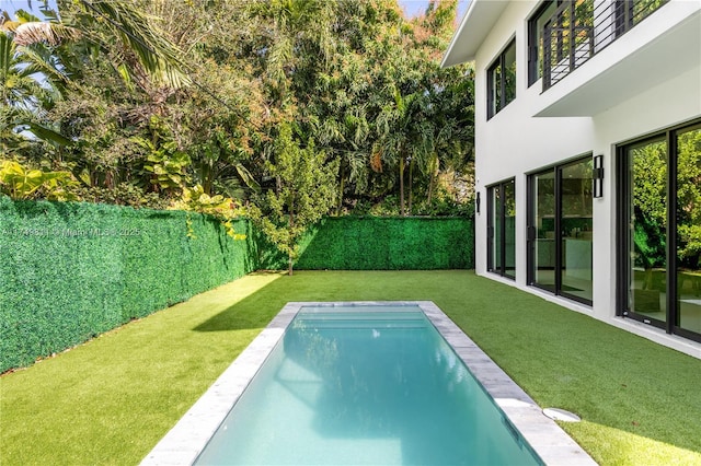 view of swimming pool featuring a yard, a fenced backyard, and a fenced in pool