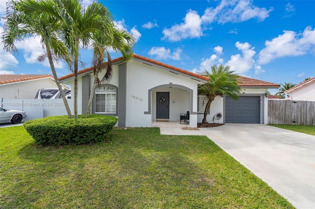 mediterranean / spanish house with driveway, a front yard, a garage, and stucco siding