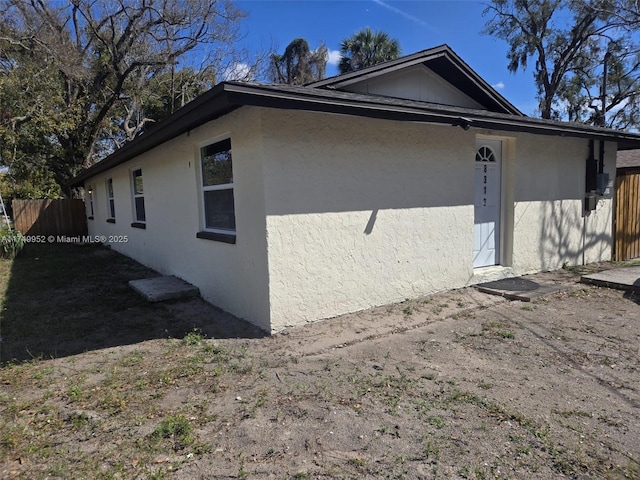 view of home's exterior featuring fence and stucco siding