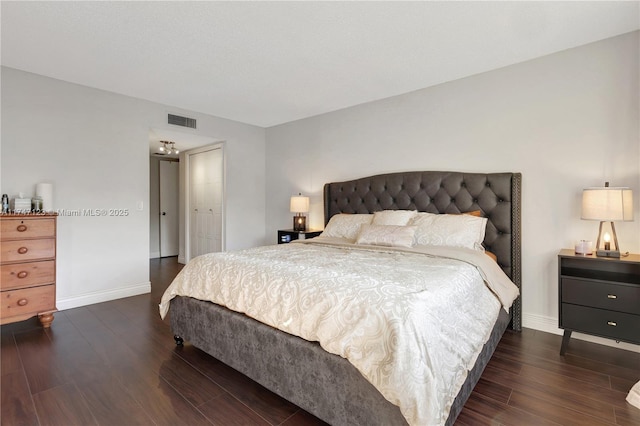 bedroom with baseboards, visible vents, and dark wood-type flooring