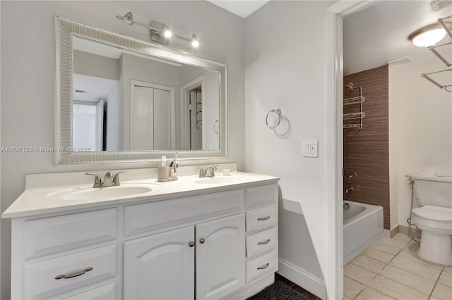 bathroom with a closet, a sink, toilet, and double vanity