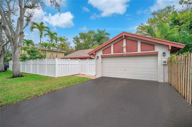 garage with driveway and fence