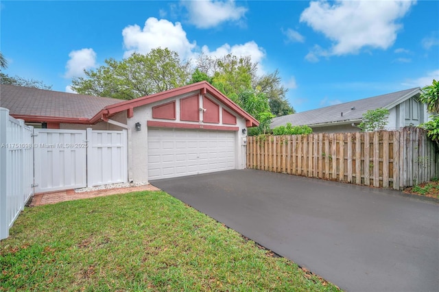 garage with fence and aphalt driveway