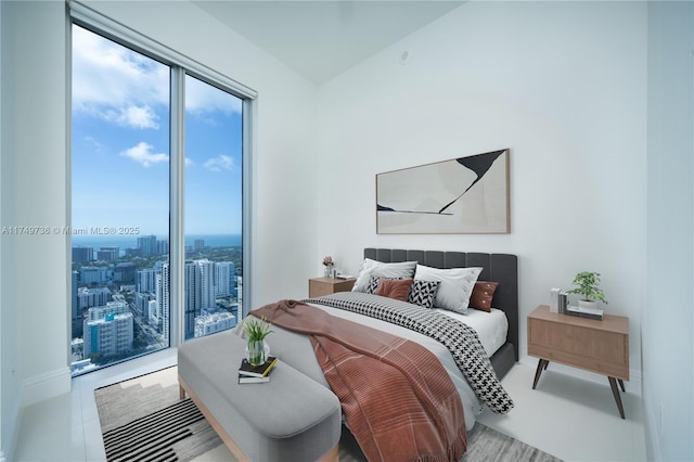 bedroom featuring multiple windows and a city view