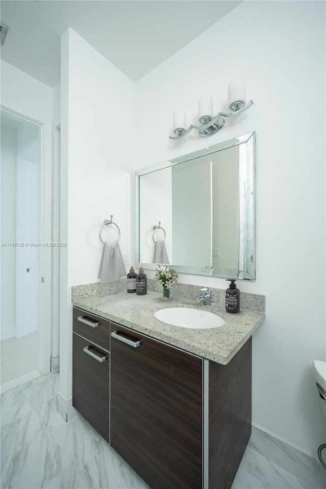 bathroom featuring toilet, marble finish floor, and vanity