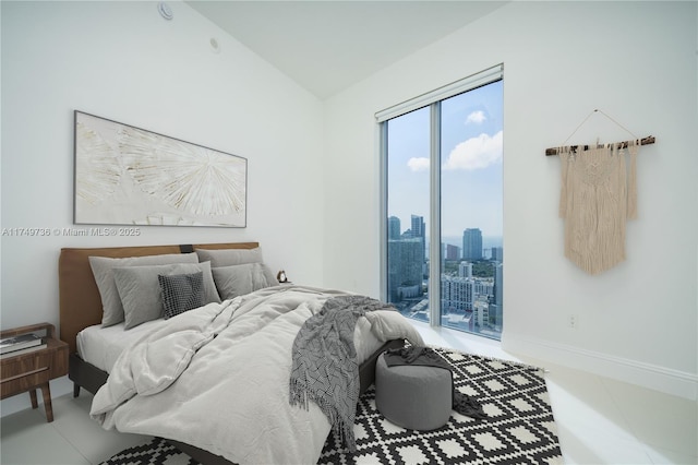 bedroom with a view of city, access to outside, lofted ceiling, and baseboards