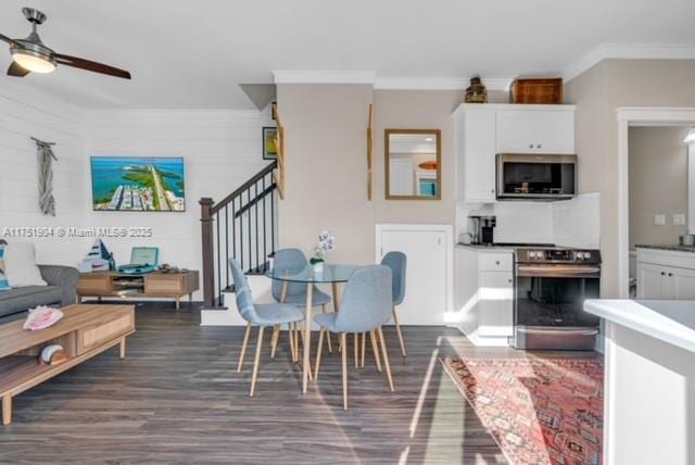 interior space featuring white cabinets, ornamental molding, stainless steel appliances, and dark wood-style flooring