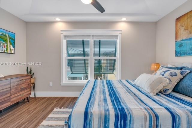 bedroom featuring a ceiling fan, baseboards, wood finished floors, and recessed lighting