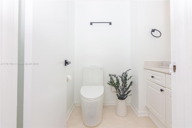 bathroom featuring baseboards, vanity, toilet, and tile patterned floors