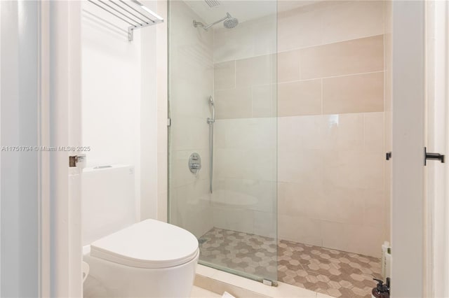 full bath with tiled shower and toilet