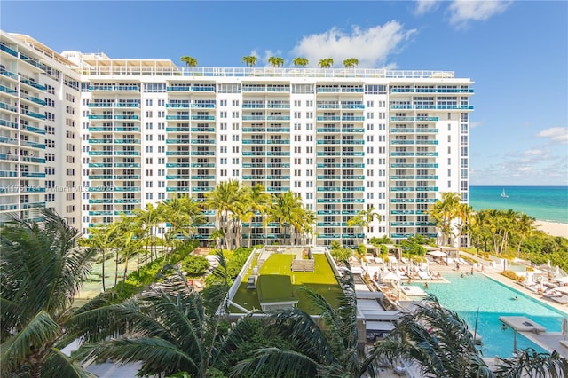 view of building exterior with a water view and a community pool