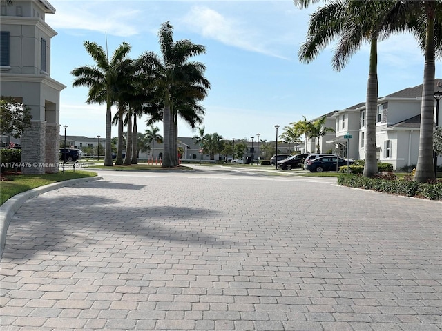 view of street with a residential view, street lights, and curbs