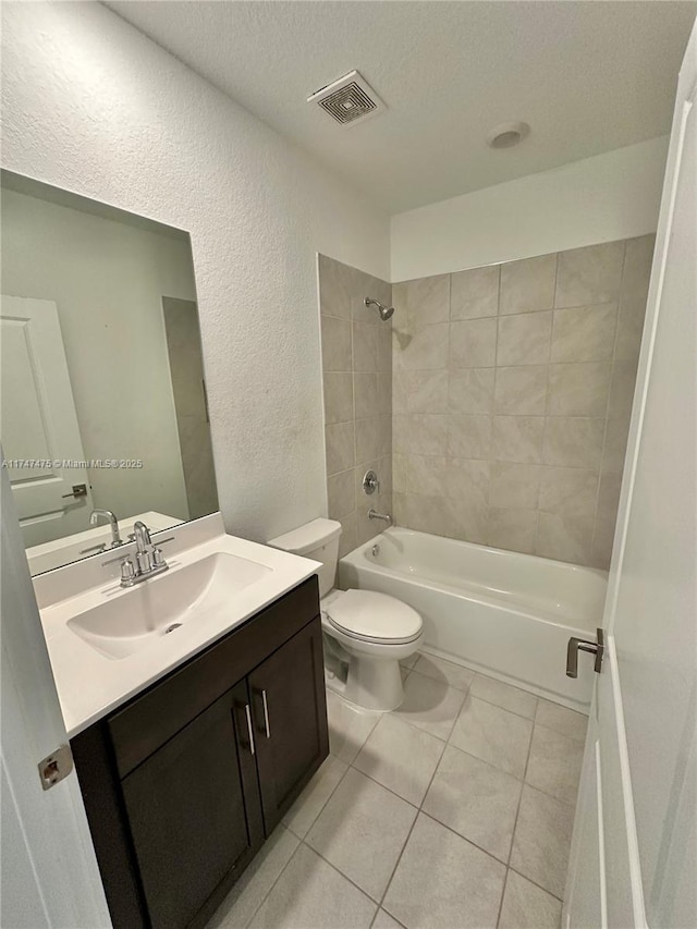 bathroom featuring a textured wall, toilet, vanity, visible vents, and  shower combination