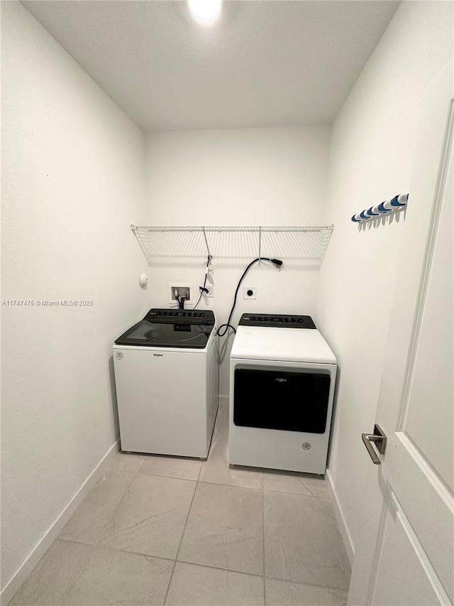 washroom with laundry area, baseboards, and washer and dryer