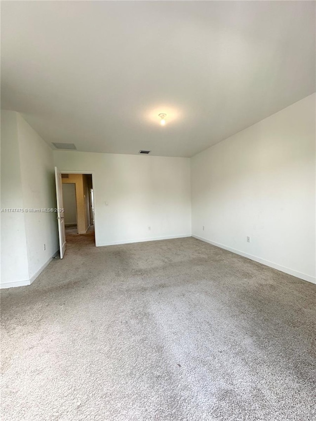 carpeted empty room with visible vents and baseboards