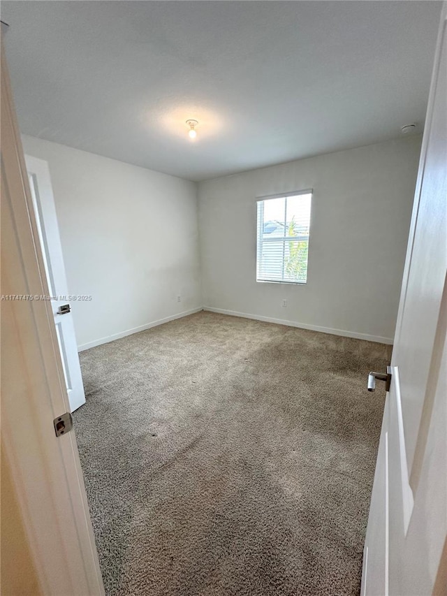 spare room with carpet floors and baseboards