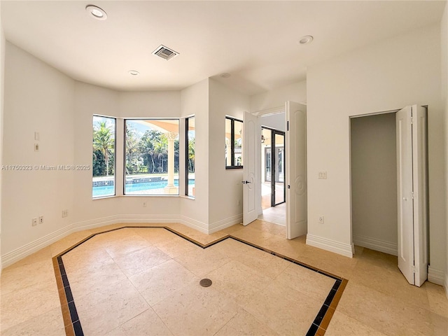 spare room with recessed lighting, visible vents, and baseboards