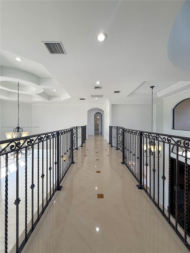 hallway featuring crown molding, recessed lighting, a raised ceiling, visible vents, and a chandelier