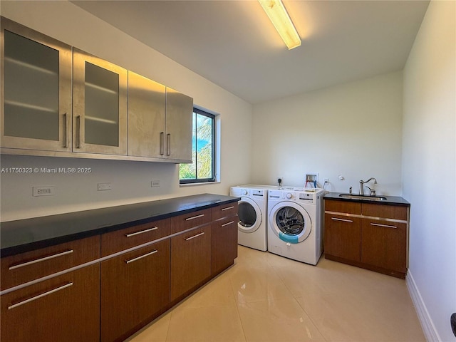 laundry area featuring cabinet space, washing machine and dryer, light tile patterned flooring, a sink, and baseboards