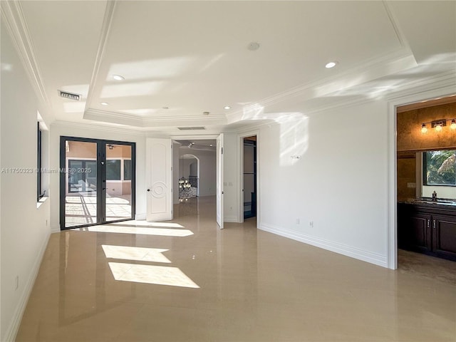 spare room featuring a tray ceiling, french doors, visible vents, and crown molding