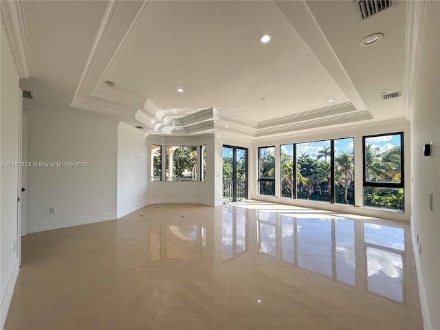 spare room with visible vents, a raised ceiling, and crown molding