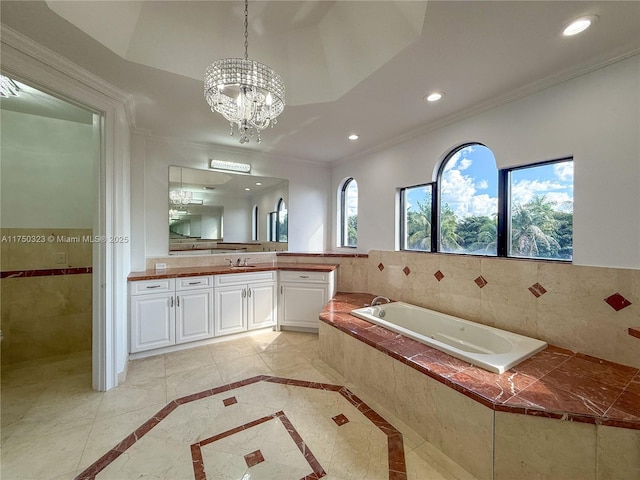 bathroom featuring a garden tub, a notable chandelier, recessed lighting, ornamental molding, and vanity