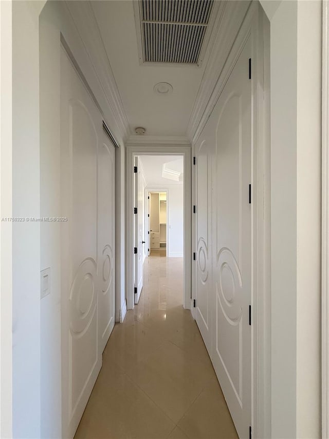 hallway with visible vents, crown molding, and light tile patterned floors