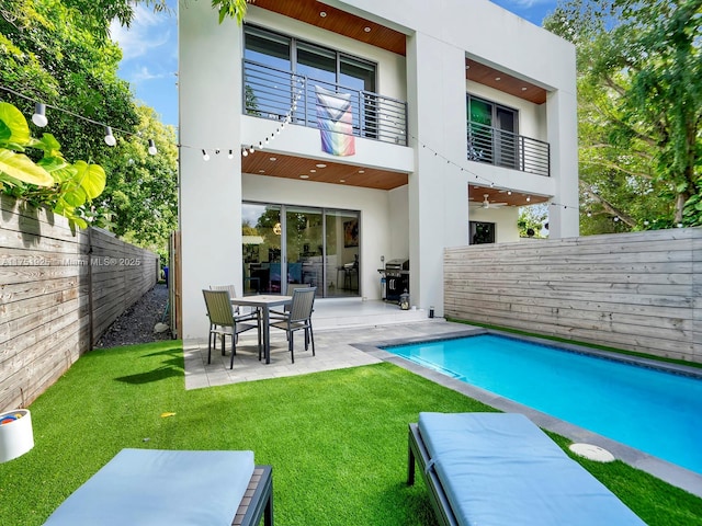 back of property featuring a patio, a fenced backyard, a balcony, and stucco siding